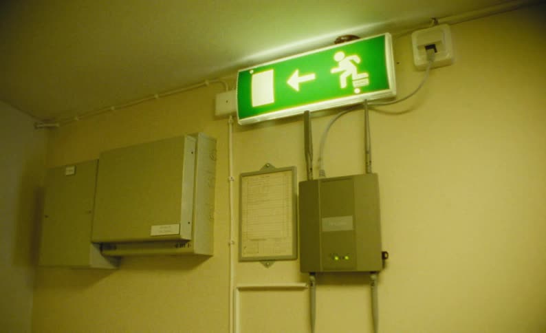 Shot of a yellow room and a green exit sign