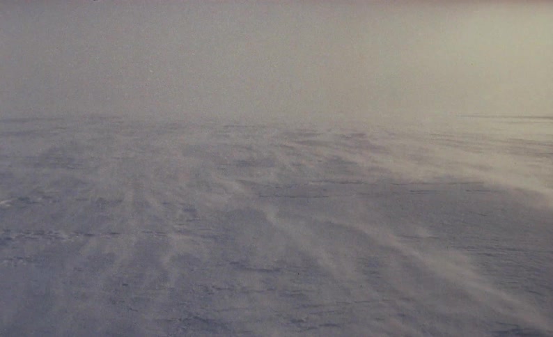 A view of snow blowing on a mountain