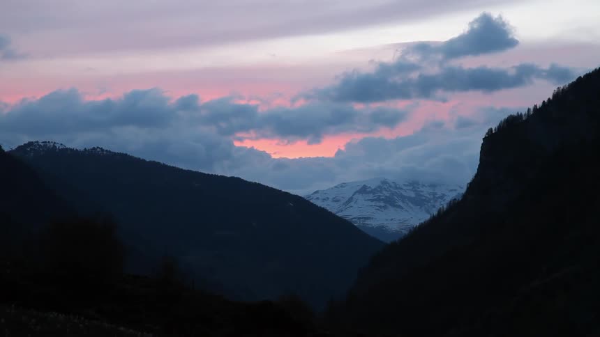 A mountain range is covered with clouds and snow