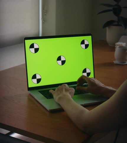 A person is typing on a laptop while sitting indoors