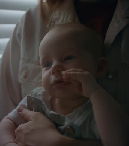 Mother in white jacket holds baby son