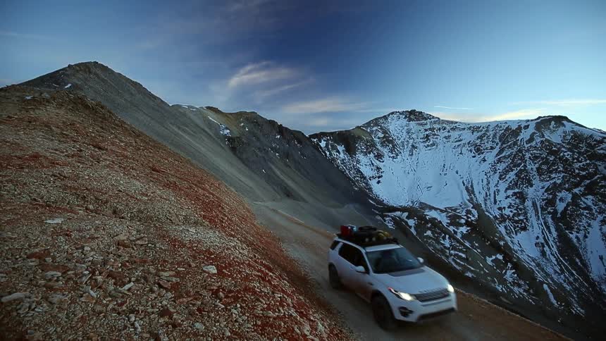 A car drives down a steep mountain road