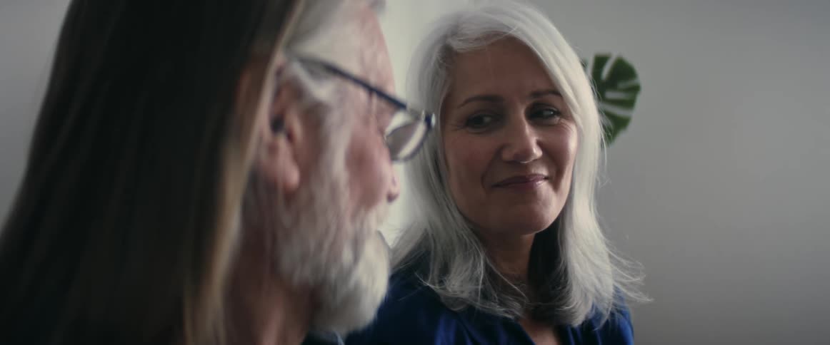 A senior couple sitting in a room smiling