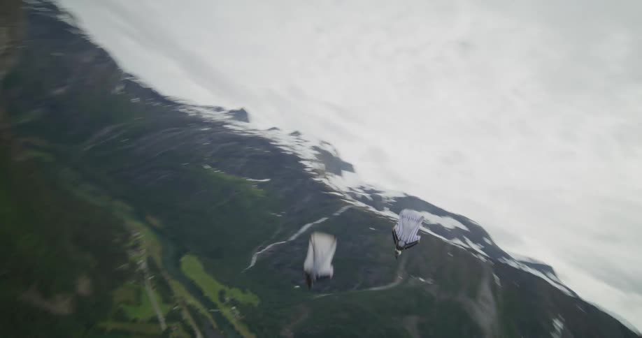 Two people sky diving in suits