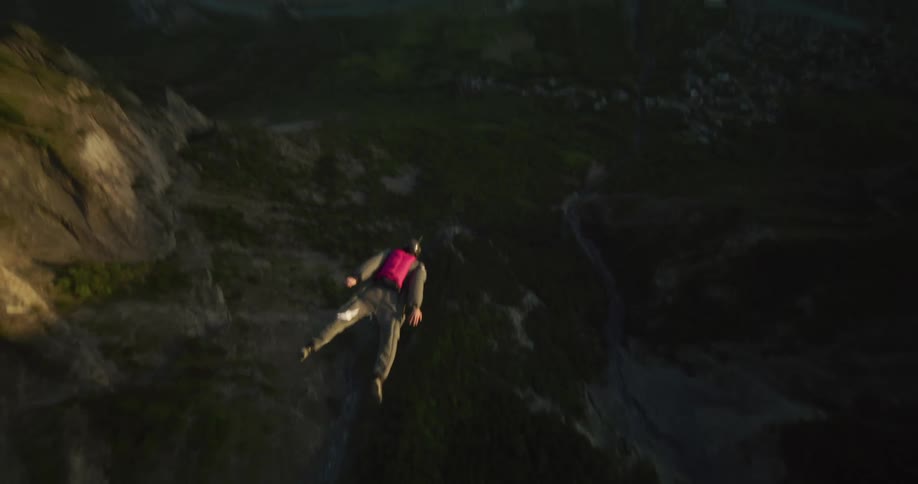 A man base jumping off a cliff