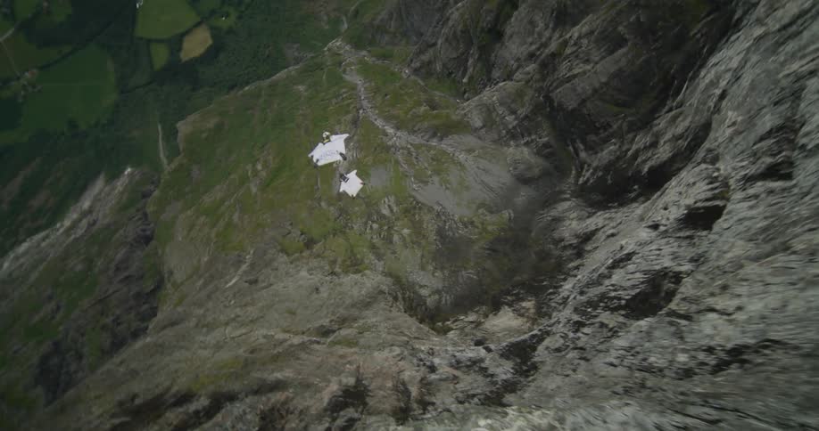 Two men jump off a cliff and glide