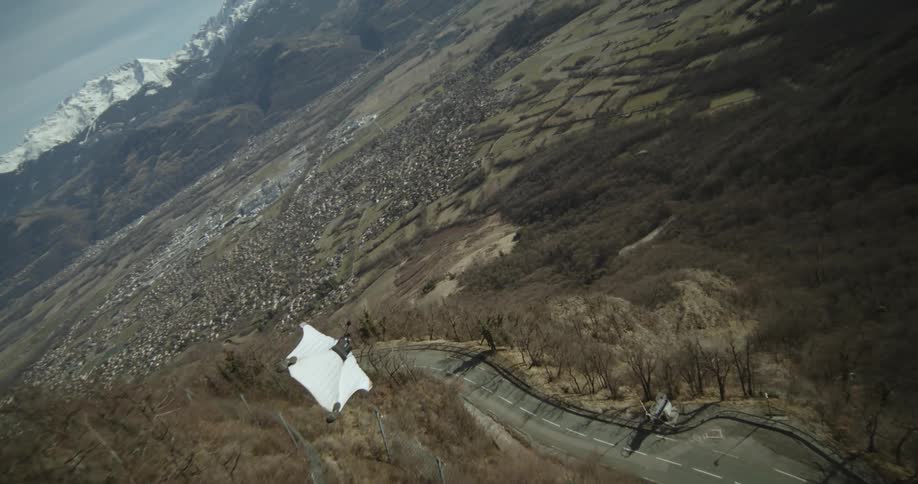 A base jumper soars through the sky