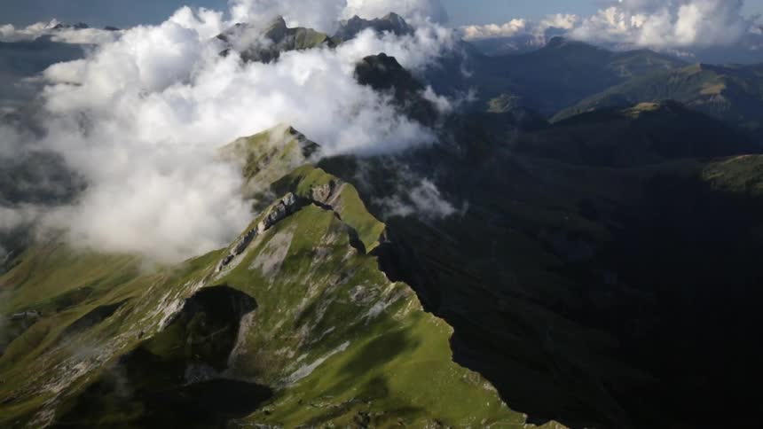 Clouds move over a sharp mountain