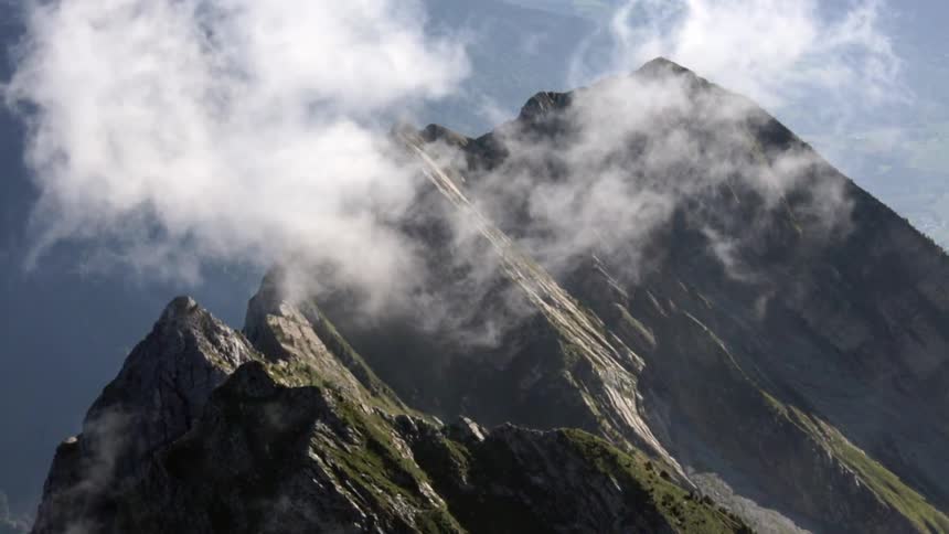 Clouds hovering above mountain peaks