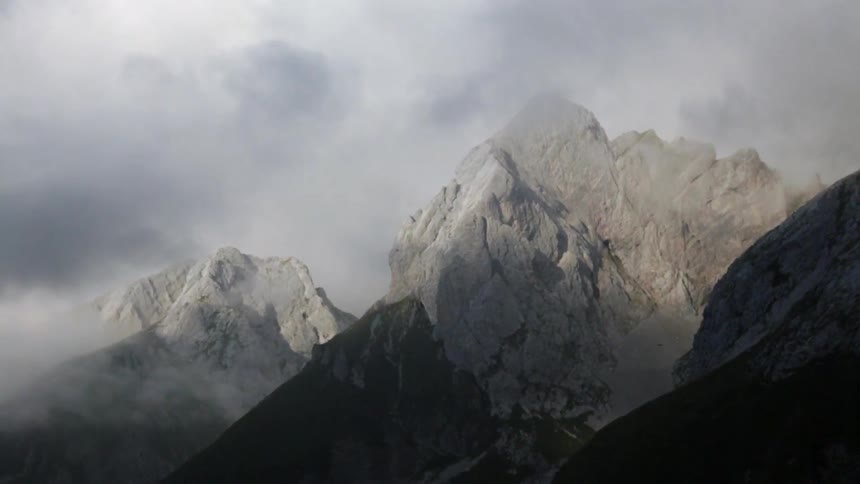 Clouds float over rocky mountain peaks