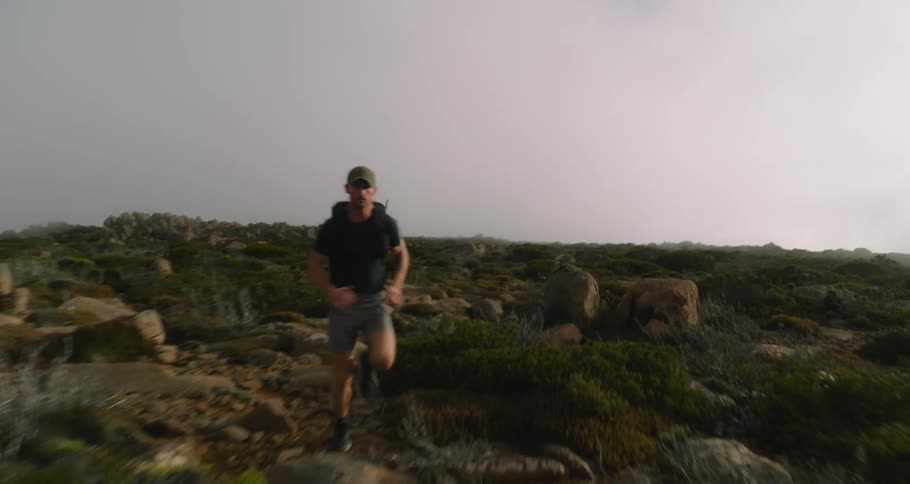 A man runs through rocks in a canyon