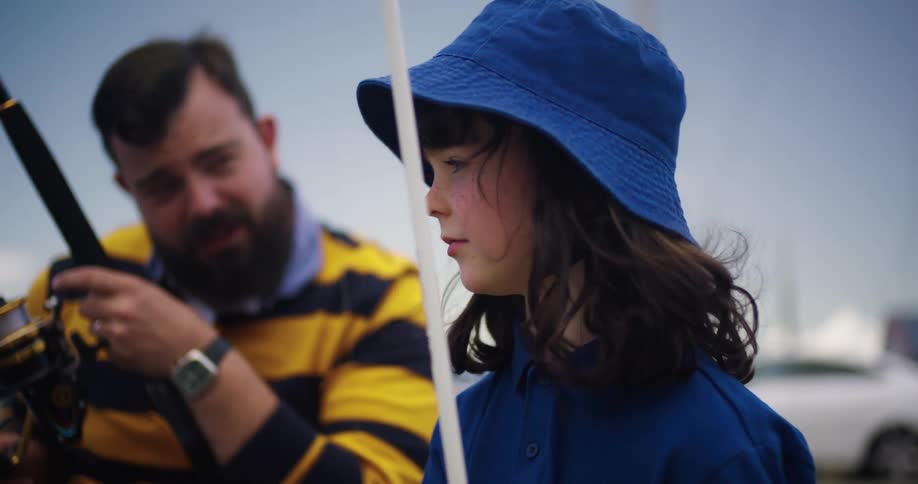 Father and daughter are fishing on a lake in the day time
