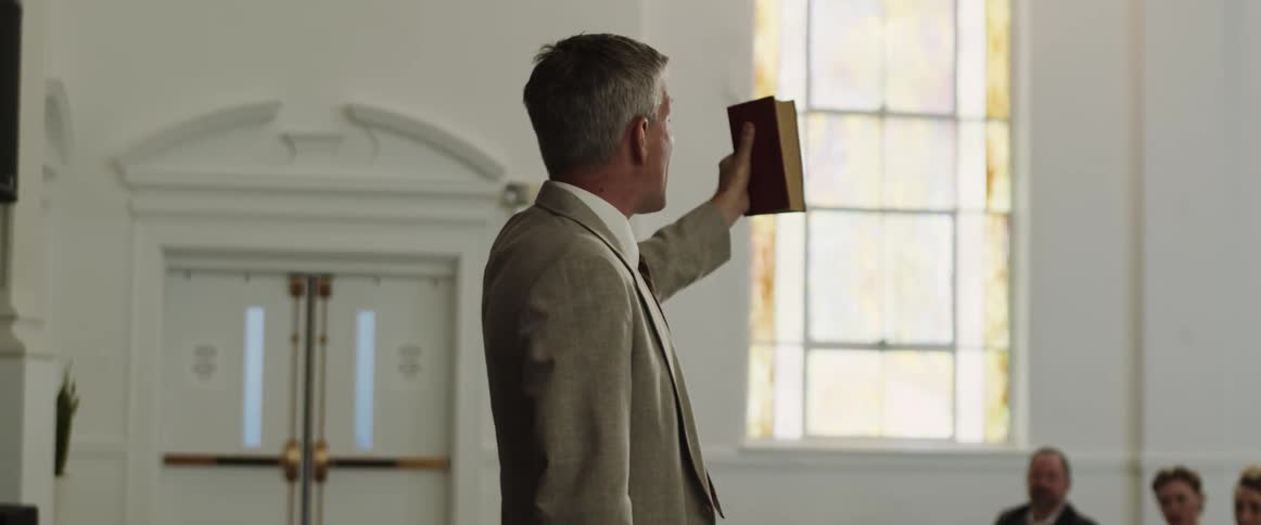 A pastor making a sermon and holding a bible