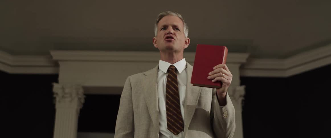 A man is standing in a room and holding a book