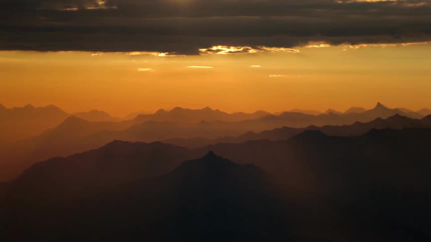 The clouds sit above the mountains at dawn