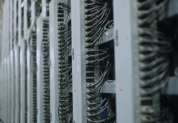 Rack focus on rows of servers in warehouse