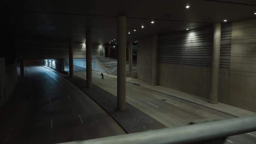 Person riding a bike on the empty road through a tunnel