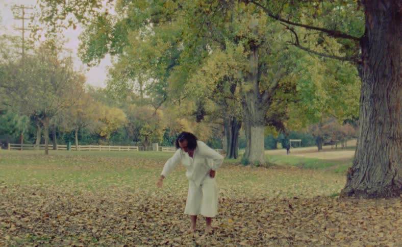 A man is dancing outdoors in the middle of the day time