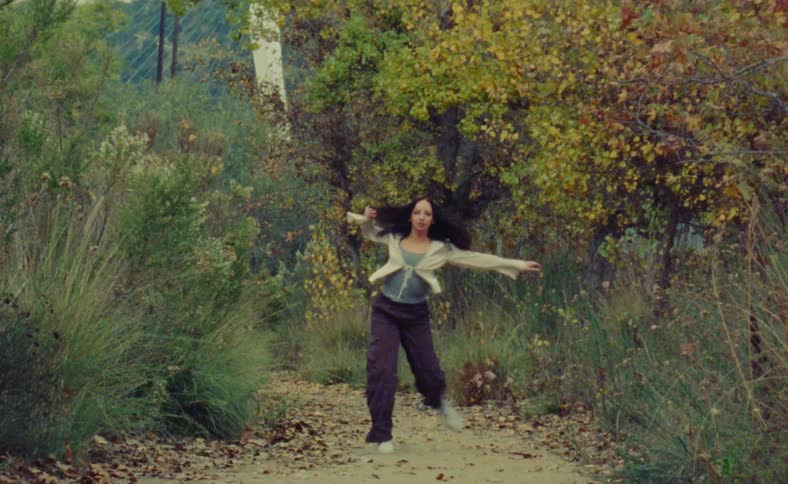 A woman is dancing outdoors by herself