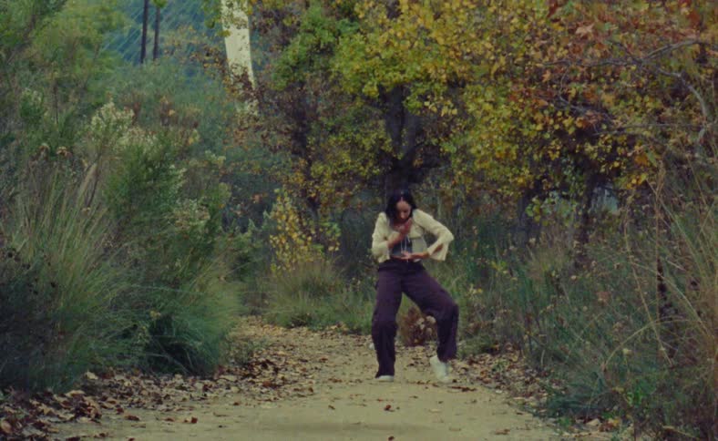A young woman is dancing around the nature area