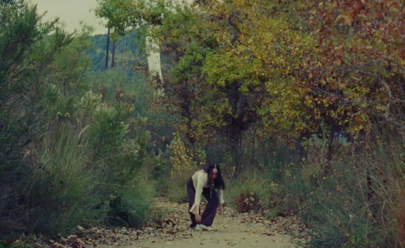 Film footage of a woman dancing outdoors by nature