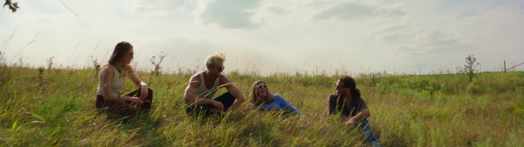 Friends hanging out on a grassy pasture in the countryside