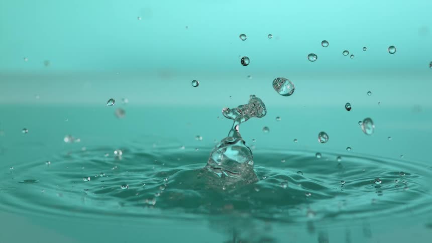 Droplets of water fall on to a water surface and form bubbles and ripples