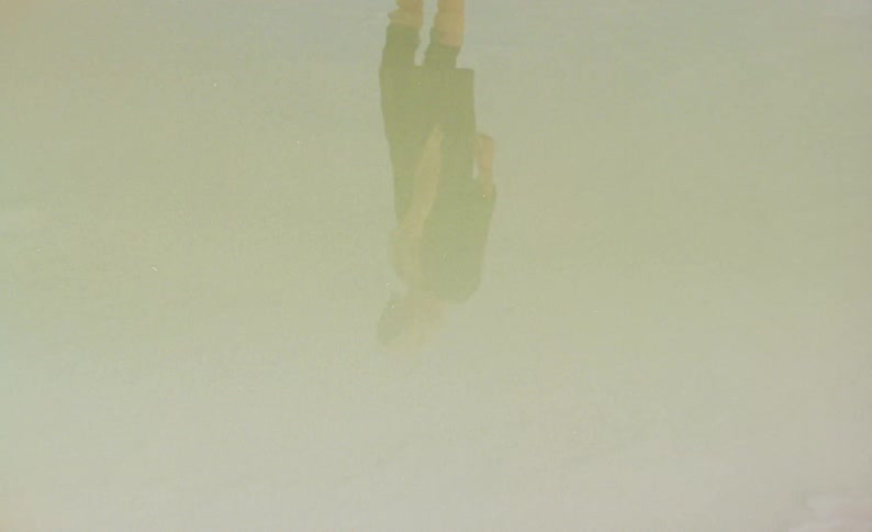 A persons reflection slowly walking