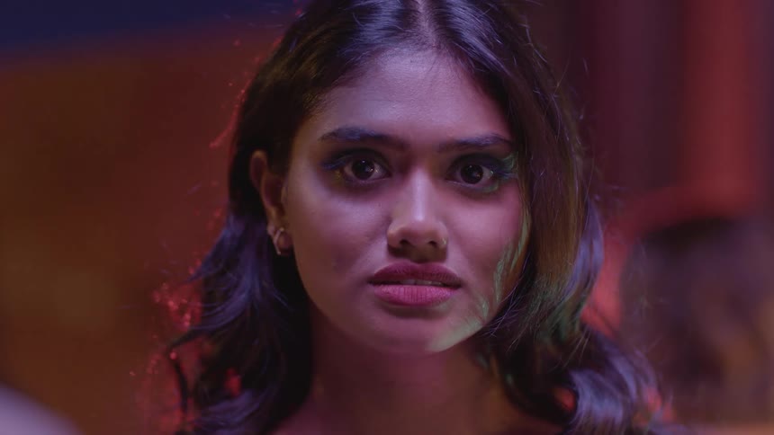 A woman staring and talking solemnly slightly raising her eyebrows