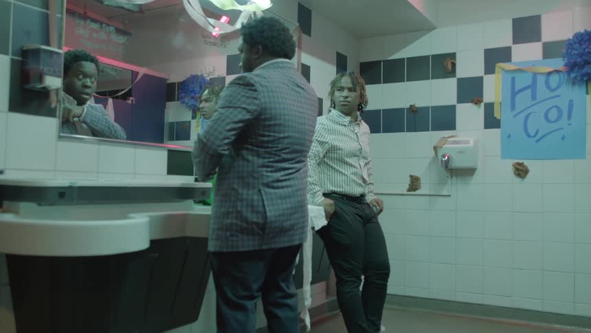 Two black men having a discussion inside a bathroom