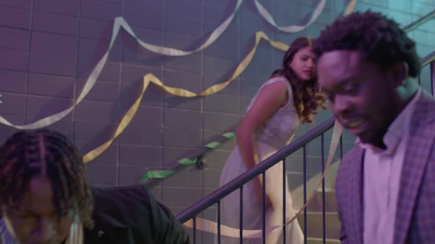 A girl punches a boy in the face at a party
