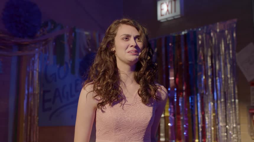 A young woman cries and runs out of a school dance