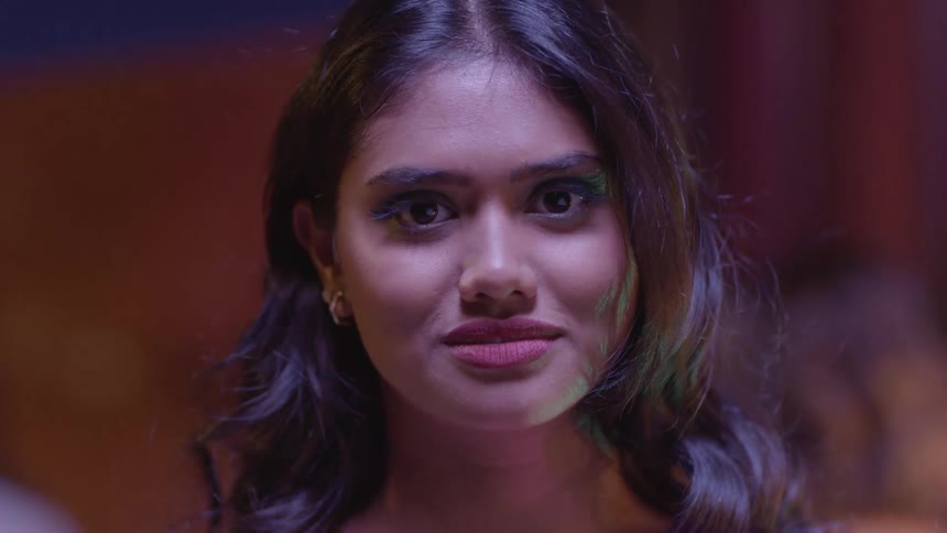 A woman smirking and talking to someone and then getting angry and aggressive and swinging her arm at them