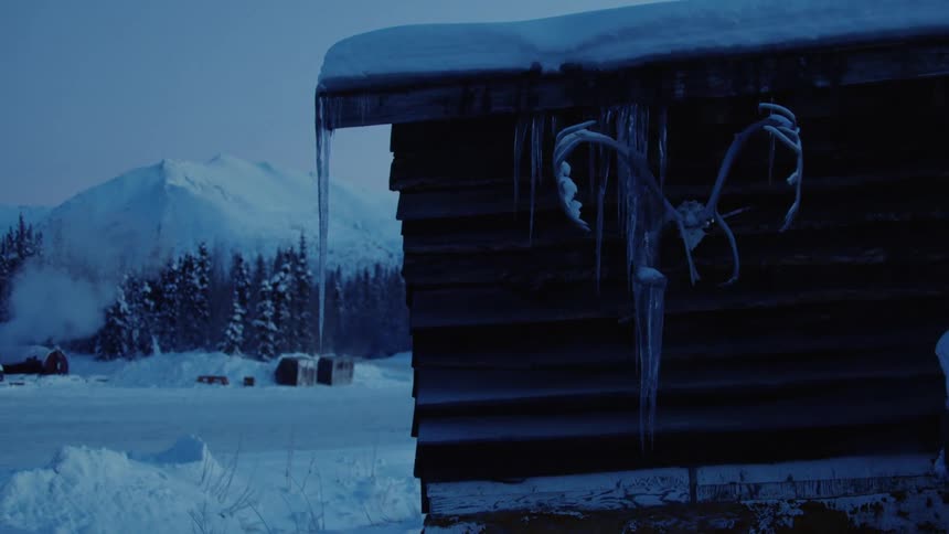 Icicles hanging on a cottage by a mountain
