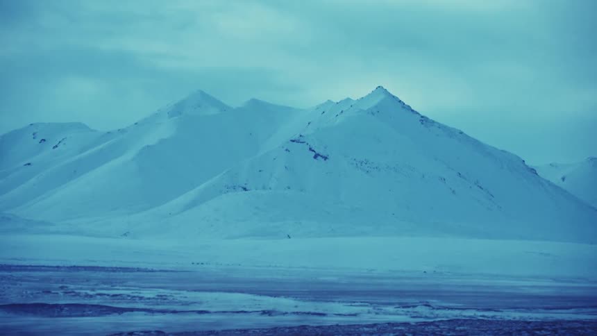 A heavy blanket of snow covers the entirety of a mountain range