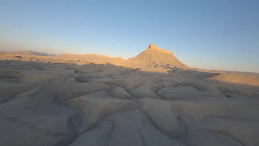 Flight over some cliffs towards a mountain in the desert