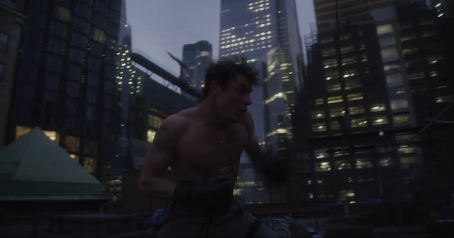 A man shadow boxing on a roof