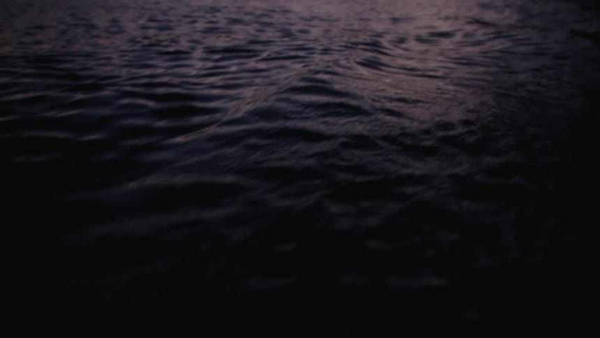 Ocean waves and ripples created by piloting a boat at dusk
