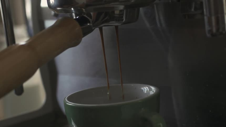 A machine is pouring a drink into a cup