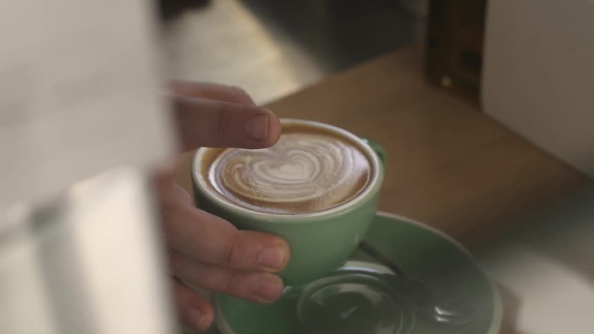 A person sets down a coffee drink