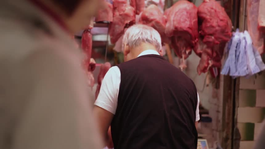 A butcher packages up meat at a market in Hong Kong