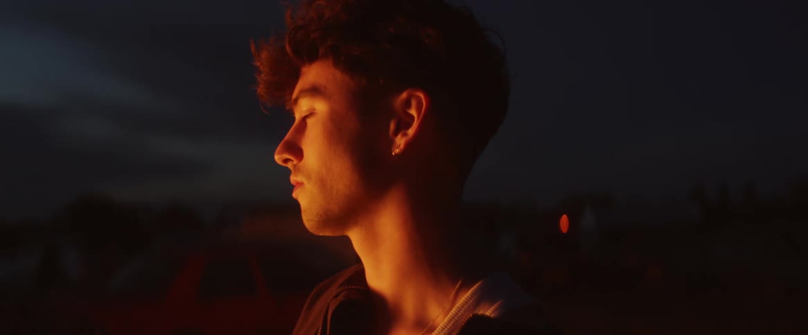 Boy watches bonfire at night