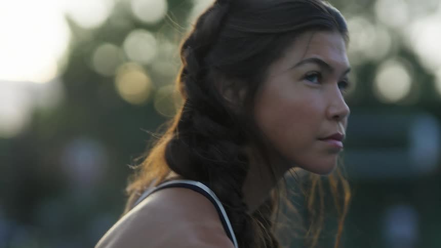 Close up of the face of a young fit woman sitting outdoors at morning