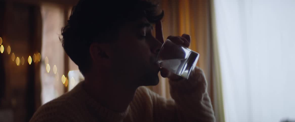 A man is drinking at home