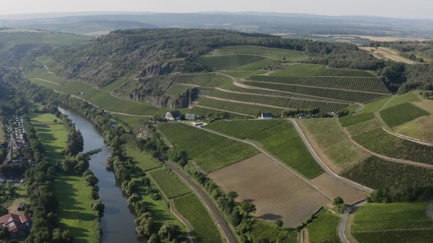 Aerial view of field plots on a hill with a river running through