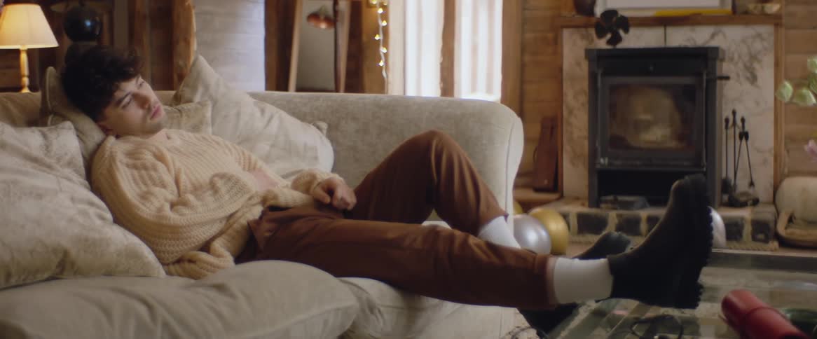 A boy sits slumped on a couch looking sad