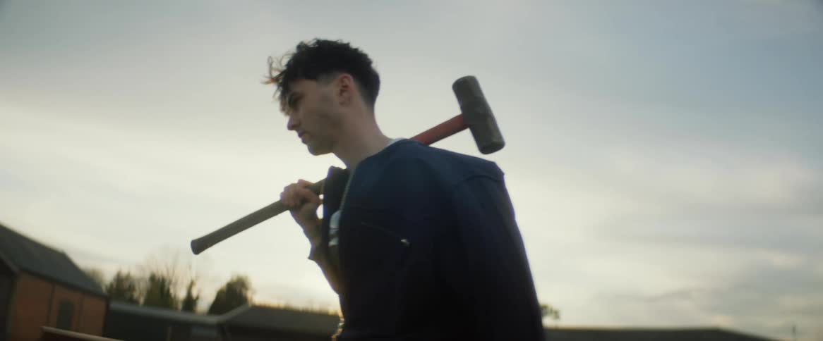 A man is carrying a sledgehammer