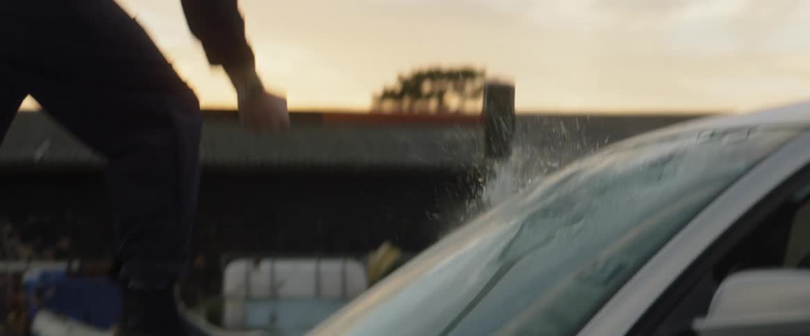 A man smashes a vehicles windshield with a sledgehammer