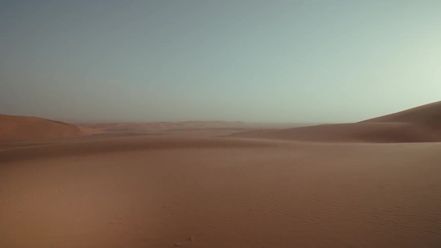 Sand in the empty desert is shown against the sky in Saudi Arabia