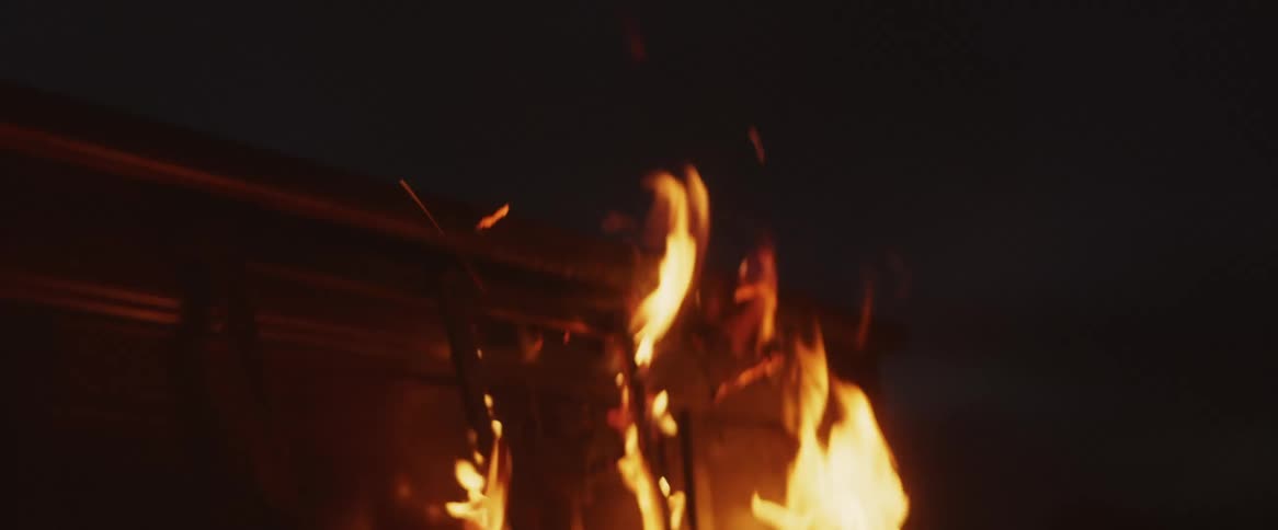 Wooden furniture is burning in flames outside at night